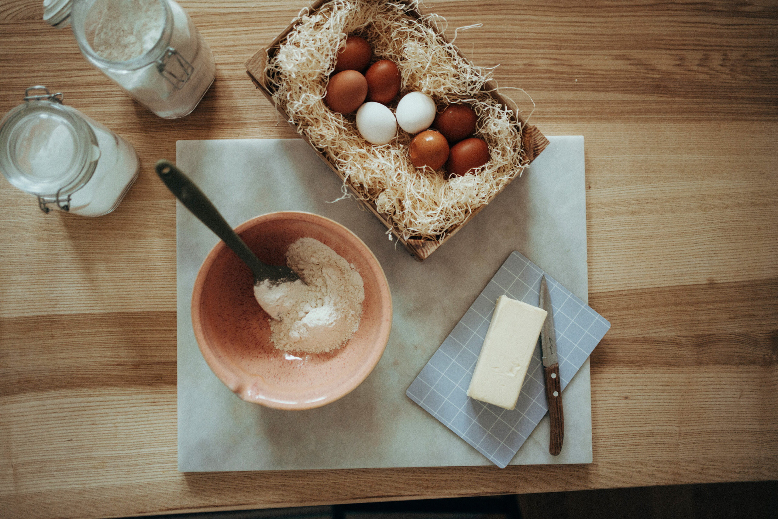 nuukk-diy-osternest-zustaten-eier-butter-mehl-web Osternest aus Hefeteig mit Osterei. Schneidebrett von nuukk mit Grid-Muster in hellblau