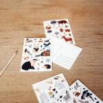 Winter Postkarte mit Waldtieren: Waschbär, Dachs, Hase mit Handschuhen und Schal, Eisstern