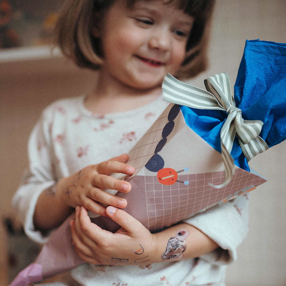 Bunte Mini-Schultüte aus Nuukk-Schreibtischunterlage gefüllt mit Spielsachen und Süßigkeiten