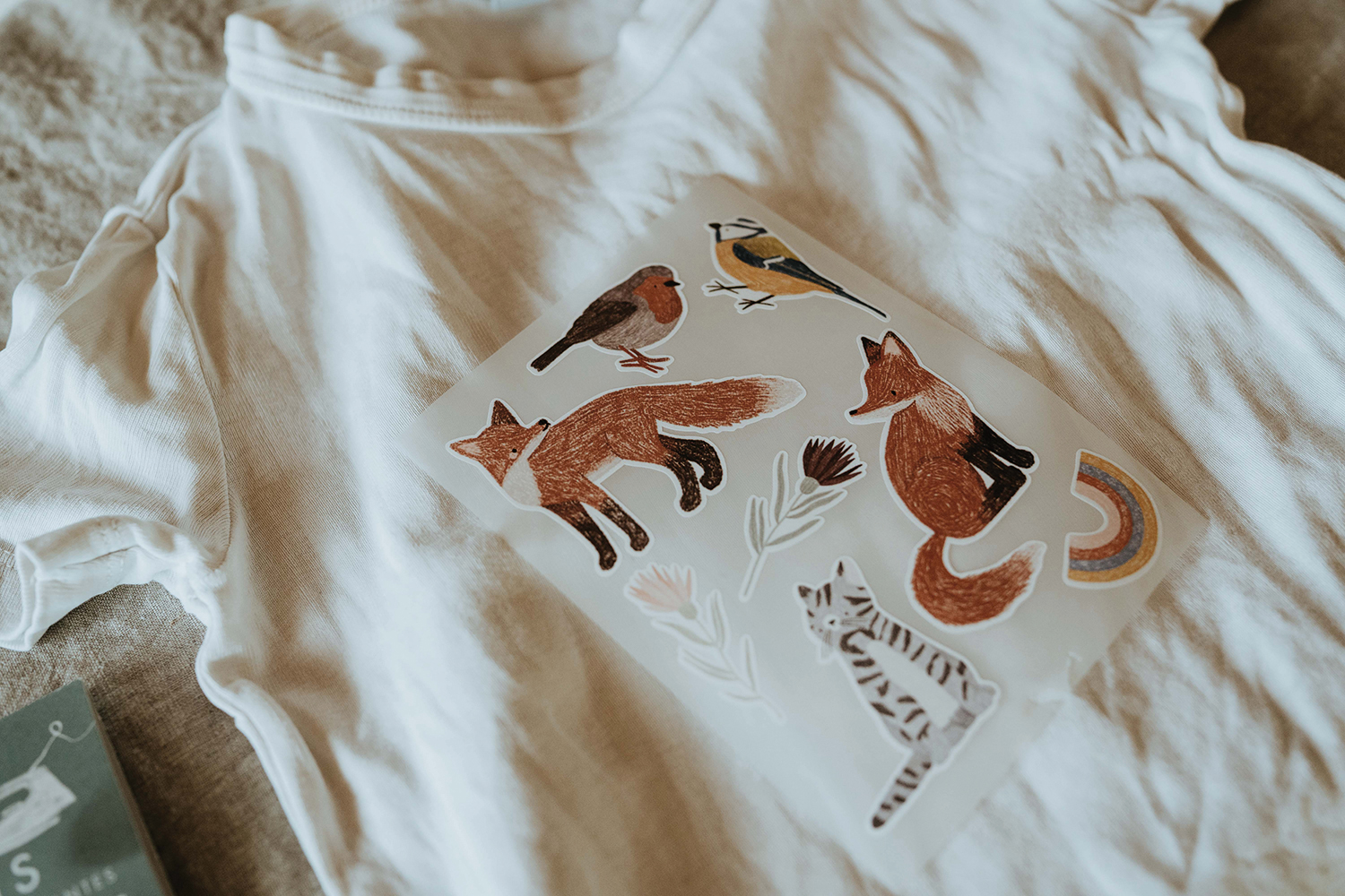 Kinder T-Shirt verziert mit Nuukk Bügelbild. Motiv: Fuchs, Katze, Rotkehlchen, Meise